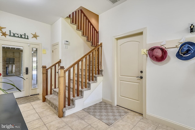 foyer entrance featuring visible vents, baseboards, and stairs