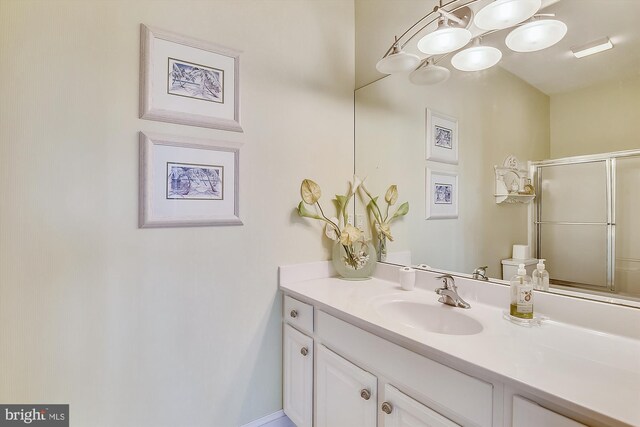 bathroom with vanity, a shower with shower door, toilet, and tile patterned floors