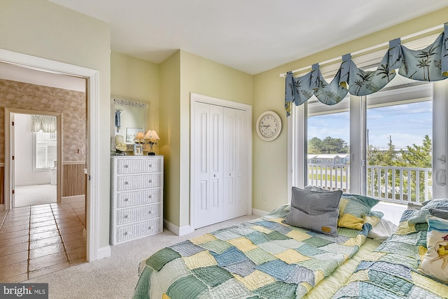 carpeted bedroom with access to exterior, a closet, and baseboards