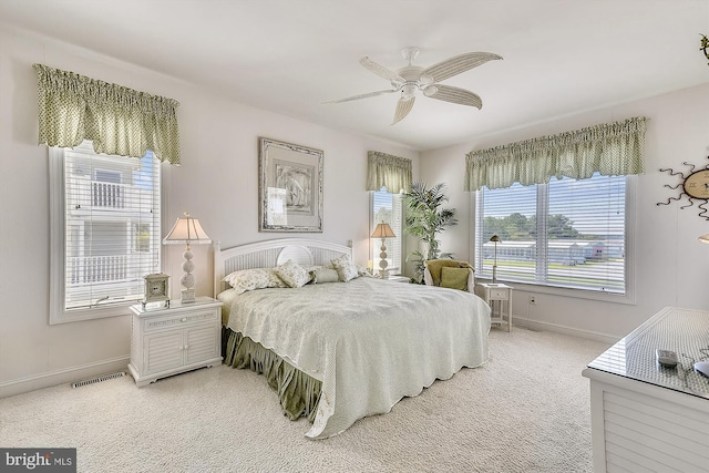 bedroom featuring baseboards, visible vents, ceiling fan, and light colored carpet