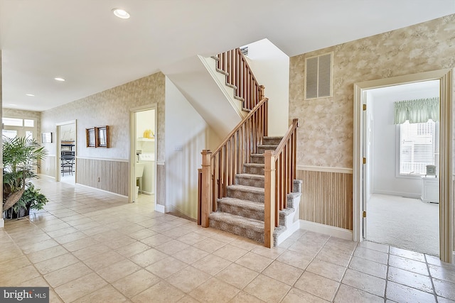 staircase featuring recessed lighting, visible vents, wainscoting, baseboards, and wallpapered walls