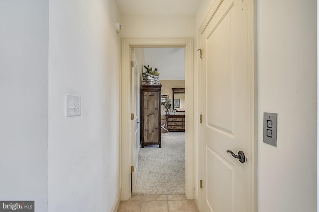 hall with baseboards and light colored carpet