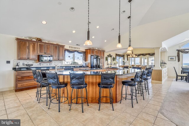 dining room with lofted ceiling, light tile patterned floors, and a wealth of natural light