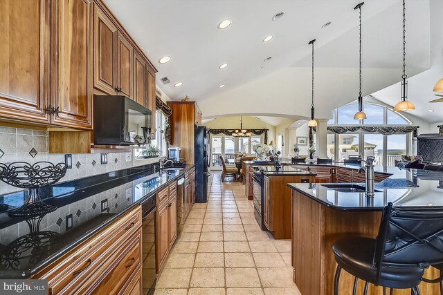 kitchen with high vaulted ceiling, kitchen peninsula, pendant lighting, a center island, and ceiling fan