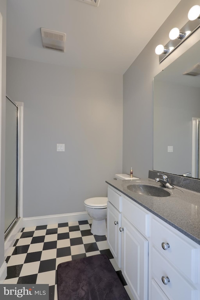 bathroom with toilet, vanity, baseboards, tile patterned floors, and an enclosed shower