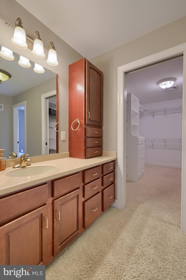 bathroom featuring a walk in closet and vanity