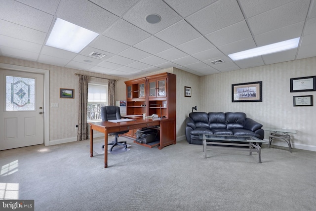 carpeted home office featuring wallpapered walls, baseboards, and visible vents