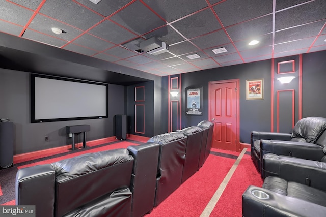 home theater with carpet, visible vents, a paneled ceiling, and baseboards