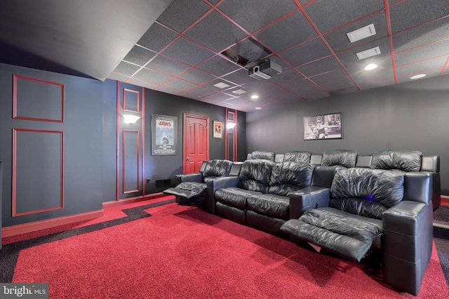 carpeted home theater with a drop ceiling, visible vents, and baseboards