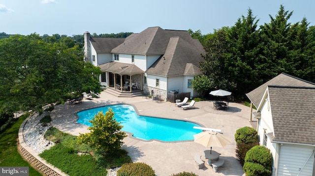 view of swimming pool with outdoor dining space, a patio area, and a diving board