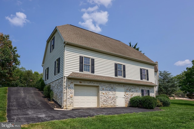 view of home's exterior featuring a yard, stone siding, a shingled roof, and a garage