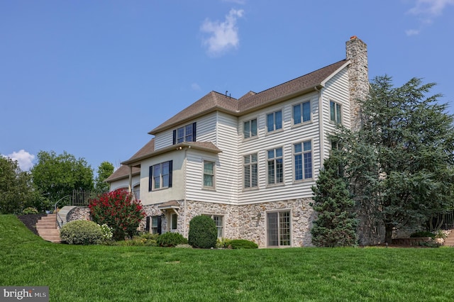 view of property exterior featuring stone siding, a lawn, and a chimney