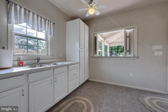 kitchen featuring plenty of natural light, white cabinetry, light countertops, and a sink