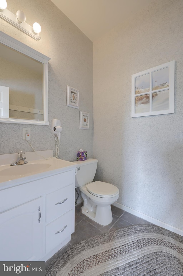 bathroom featuring tile patterned flooring, baseboards, vanity, and toilet