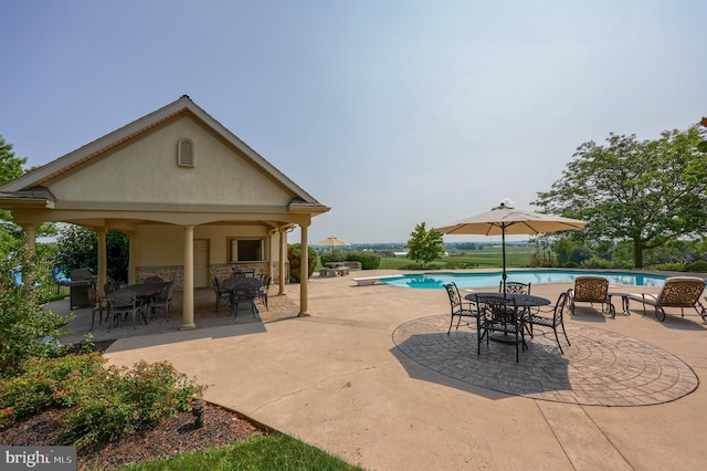 pool featuring a diving board and a patio area