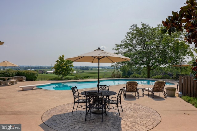 view of swimming pool with fence, a diving board, a fenced in pool, and a patio