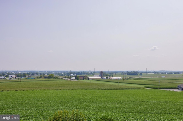 surrounding community with a rural view and a lawn