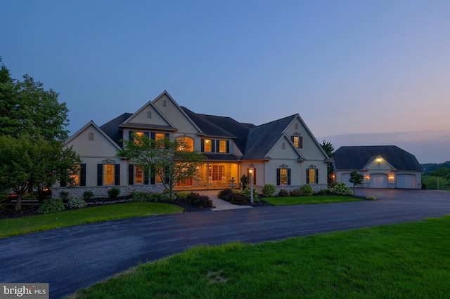 french country home featuring an outdoor structure, a detached garage, and a front lawn