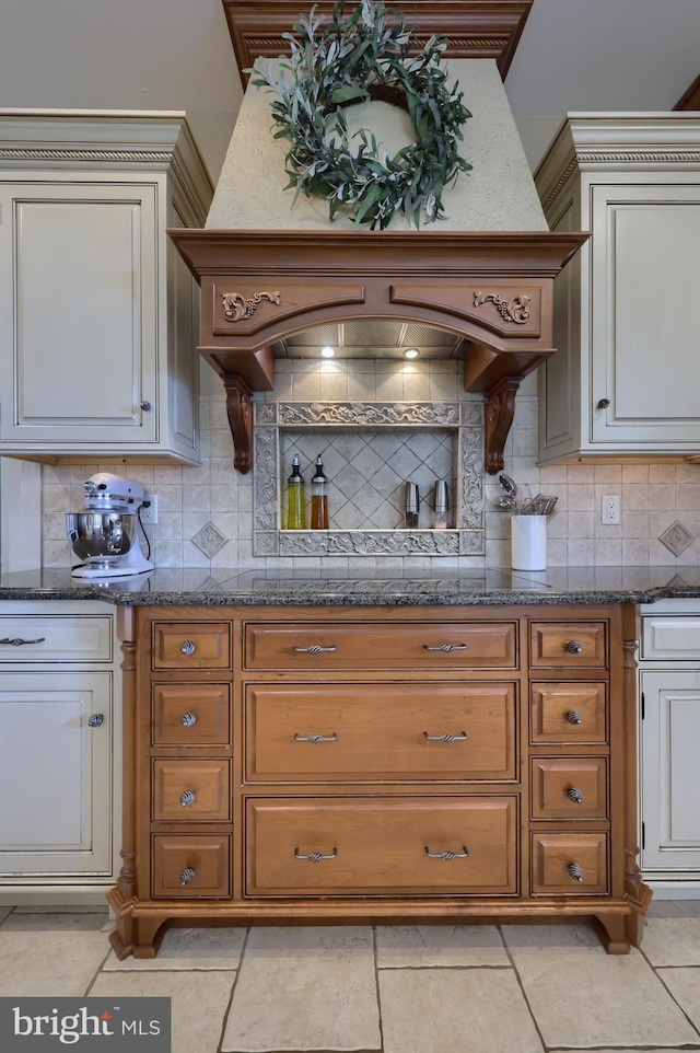 kitchen featuring dark stone counters, backsplash, and brown cabinets