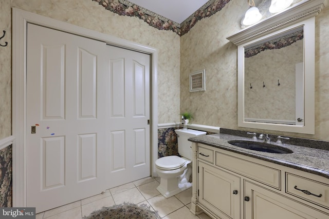 bathroom featuring toilet, wallpapered walls, tile patterned flooring, and vanity