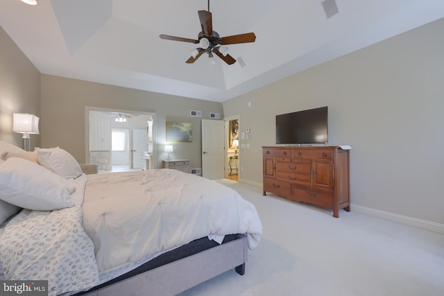 bedroom with baseboards, visible vents, a tray ceiling, and light colored carpet