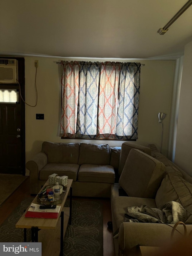 living room with wood-type flooring and a wall unit AC