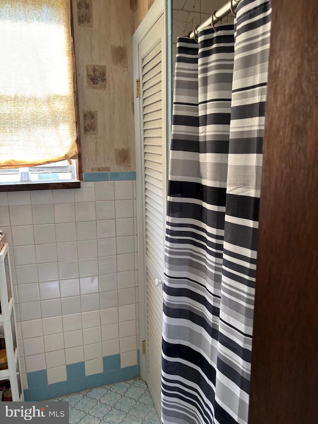 bathroom featuring tile patterned flooring and tile walls