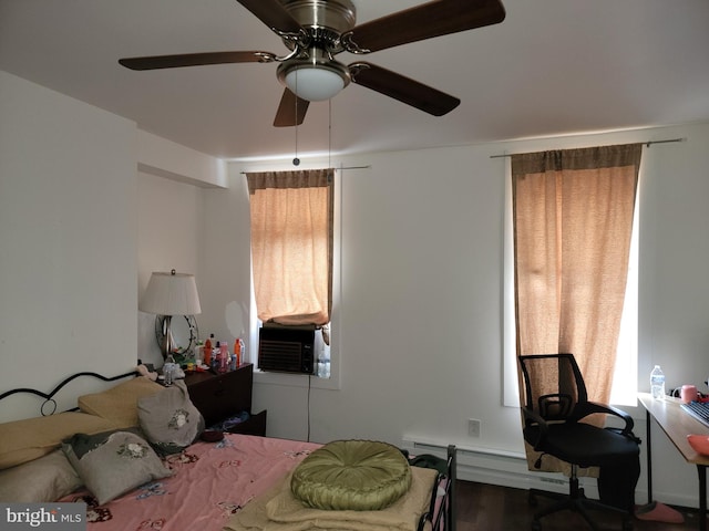 bedroom featuring a baseboard radiator, hardwood / wood-style flooring, cooling unit, and ceiling fan