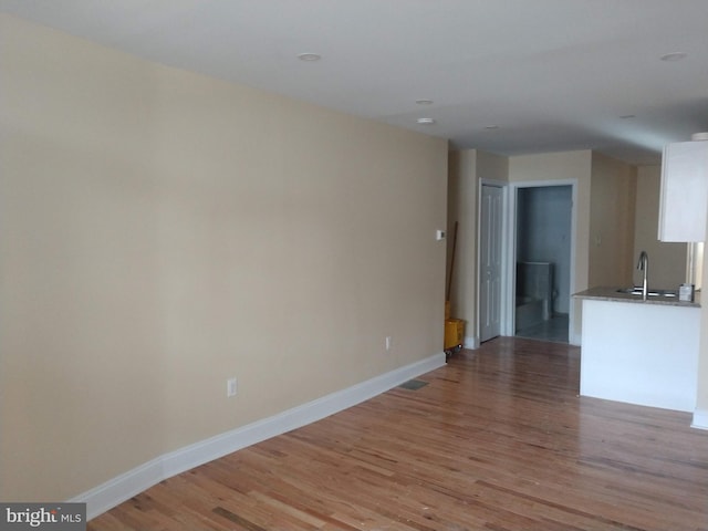 unfurnished living room featuring sink and light wood-type flooring