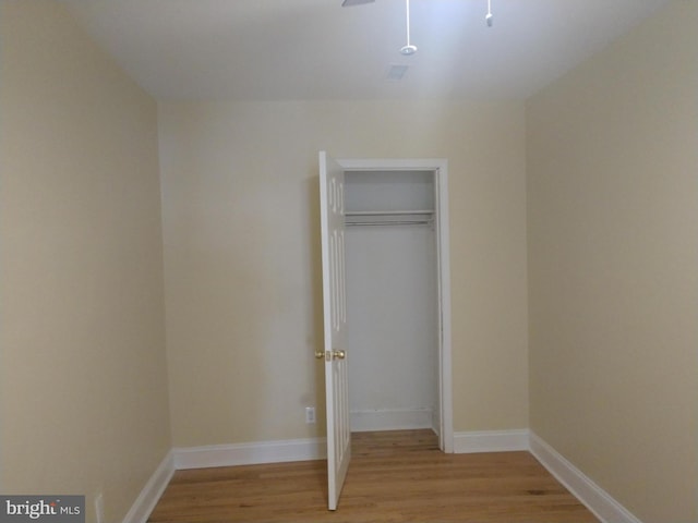 unfurnished bedroom with light hardwood / wood-style flooring and a closet