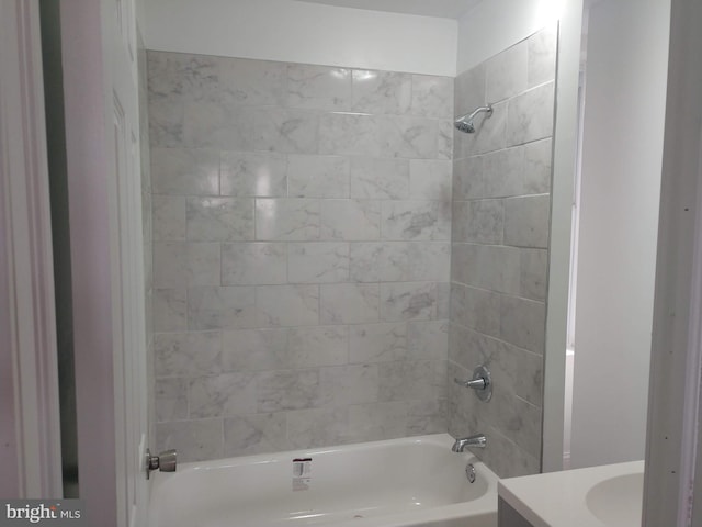 bathroom featuring vanity and tiled shower / bath