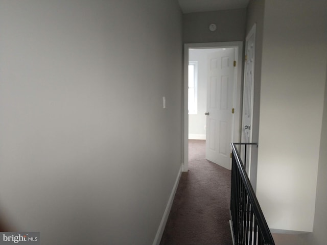 hallway featuring dark colored carpet