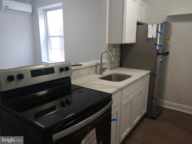 kitchen featuring a wall unit AC, stainless steel appliances, sink, white cabinetry, and tasteful backsplash