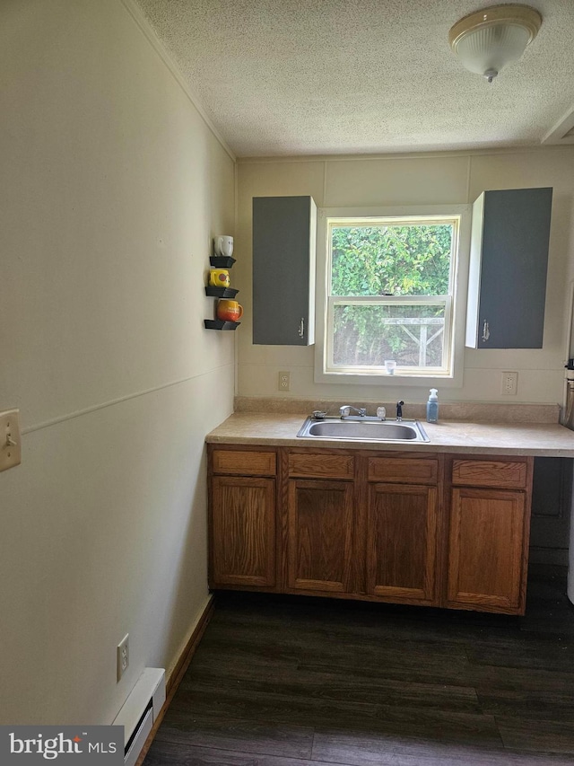 kitchen with a baseboard heating unit, dark hardwood / wood-style flooring, a textured ceiling, and sink