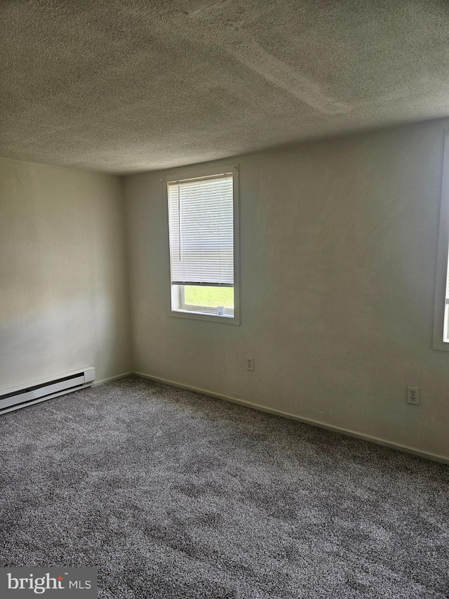 carpeted empty room featuring baseboard heating