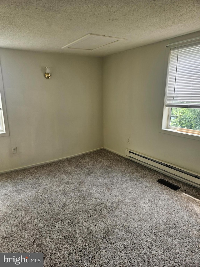 carpeted empty room featuring a baseboard radiator and a textured ceiling