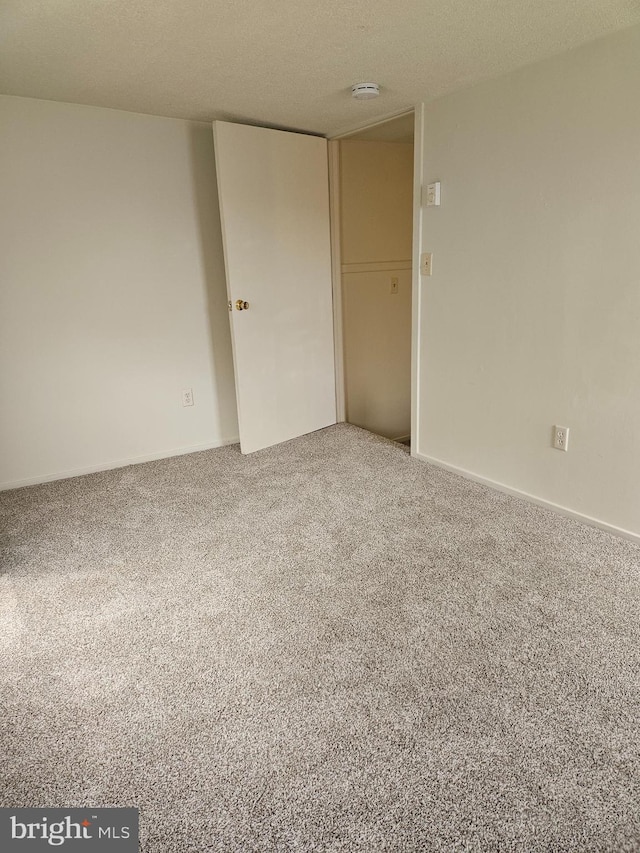 carpeted spare room with a textured ceiling