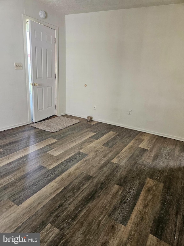 foyer entrance with a textured ceiling and dark hardwood / wood-style flooring