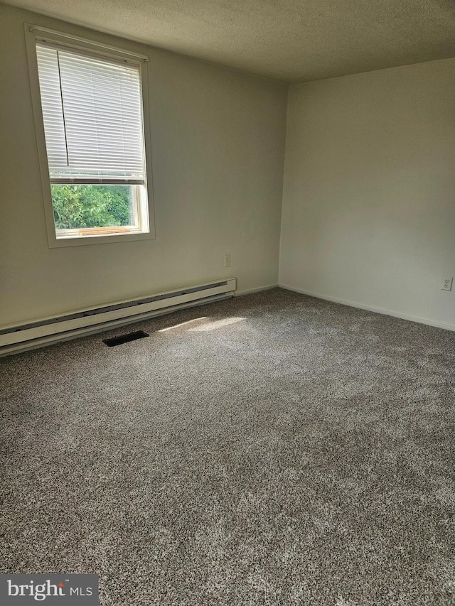 spare room featuring carpet, a baseboard heating unit, and a textured ceiling