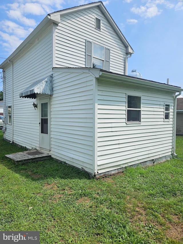 back of property featuring a yard