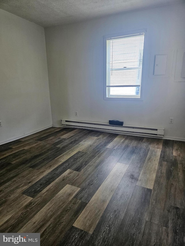 unfurnished room featuring baseboard heating, dark hardwood / wood-style flooring, and a textured ceiling