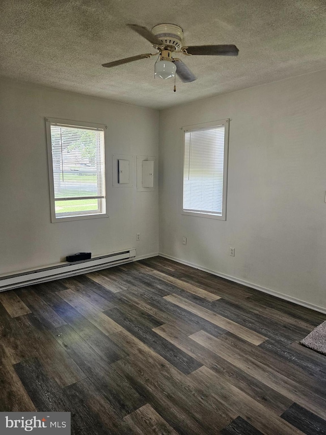 empty room featuring ceiling fan, baseboard heating, a textured ceiling, and dark hardwood / wood-style flooring