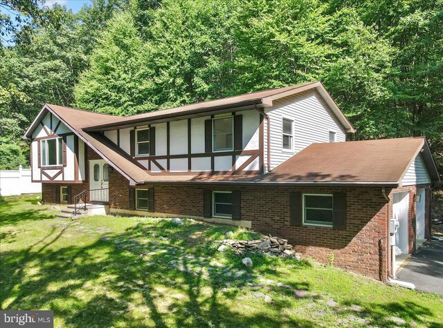 rear view of house with a yard and a garage