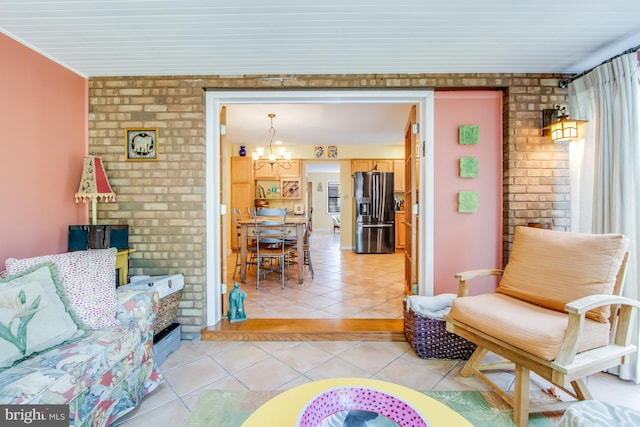 tiled living room with brick wall and a chandelier