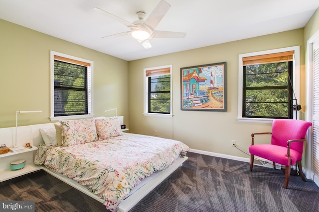 carpeted bedroom with ceiling fan and multiple windows