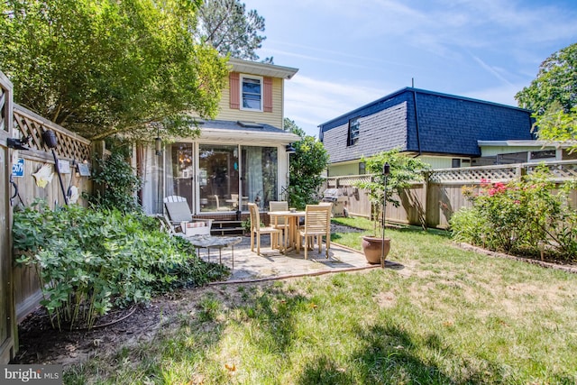 rear view of house with a patio area and a lawn