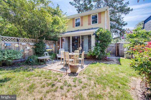 rear view of house featuring a lawn and a patio