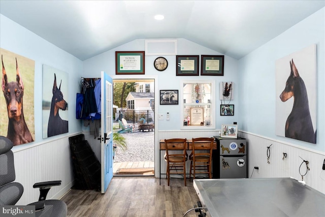 interior space featuring wood walls, lofted ceiling, and hardwood / wood-style floors