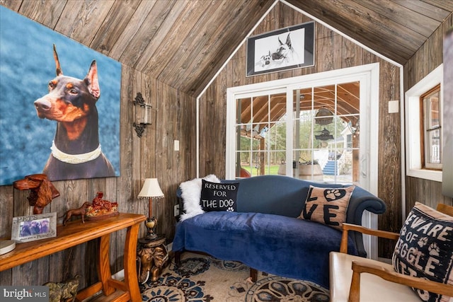 living area featuring vaulted ceiling, wood ceiling, and wooden walls