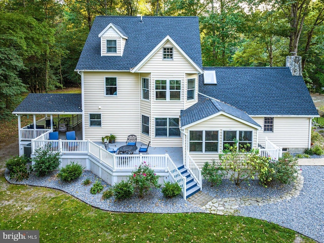 rear view of property featuring a deck and a yard